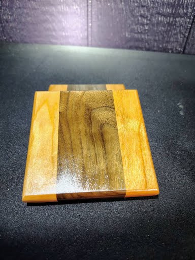 Walnut and cherry coaster top view on dark background