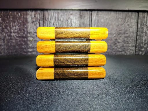 Stack of four walnut and cherry coasters showing rounded edges