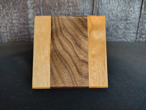 Single coaster showing walnut center and cherry border grain detail